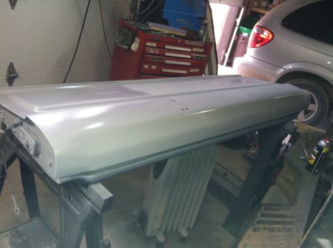 2004 Ford F-250 - A silver truck tailgate is shown in a garage setting, resting on sawhorses. A red toolbox and a silver minivan are visible in the backgroun…