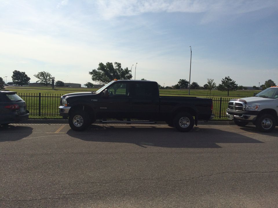Black Ford F-250 pickup truck parked next to a silver Dodge Ram pickup truck.