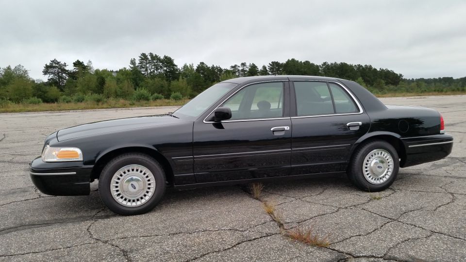 Black Ford Crown Victoria sedan driver-side profile view