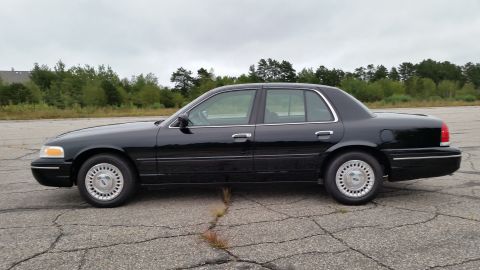 2001 Ford Crown Victoria - Photograph of a black Ford Crown Victoria sedan in profile, not a technical document.