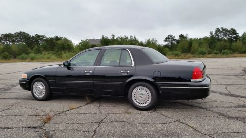 2001 Ford Crown Victoria - Photograph of a black Ford Crown Victoria sedan from the rear three-quarter, not a technical document.