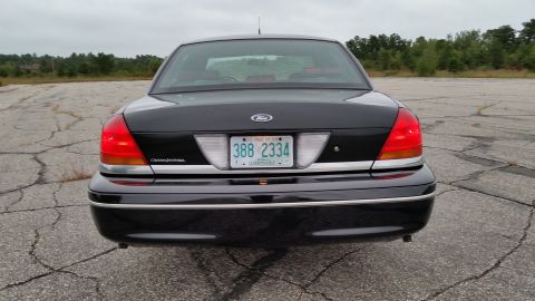 2001 Ford Crown Victoria - Photograph of a black Ford Crown Victoria sedan from the rear, not a technical document.