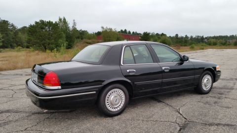 2001 Ford Crown Victoria - Photograph of a black Ford Crown Victoria sedan from the rear, not a technical document.
