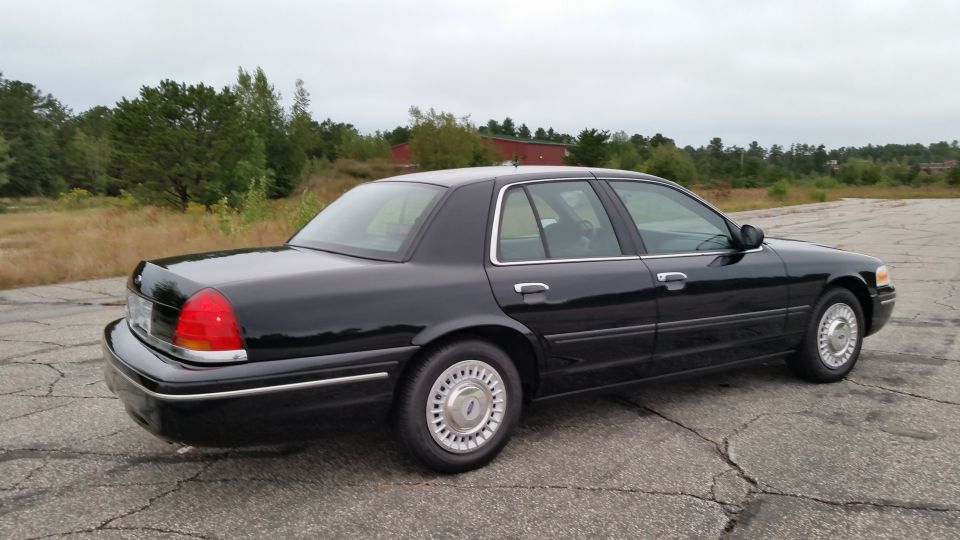 Black Ford Crown Victoria sedan rear three-quarter view