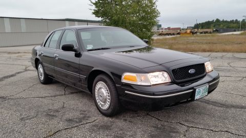2001 Ford Crown Victoria - A black 2001 Ford Crown Victoria is parked outside on a cloudy day.