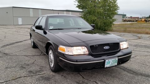 2001 Ford Crown Victoria - A black 2001 Ford Crown Victoria is parked outdoors on a cloudy day, showing its front-left quarter.