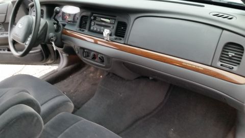 2001 Ford Crown Victoria - The interior of a 2001 Ford Crown Victoria, wood trim and a clean dashboard.