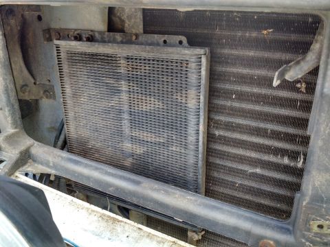 1992 Ford Bronco - Close-up view of a transmission cooler installed in front of a vehicle's radiator.