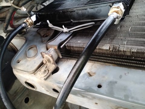 1992 Ford Bronco - Close-up view of transmission cooler lines and mounting hardware.