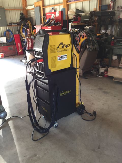 1978 Ford Bronco - A welding machine sits in a cluttered garage with tools and equipment in the background.