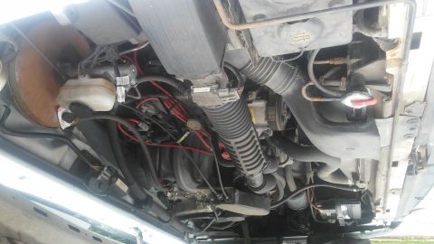 1995 Ford Bronco - Close-up view of a vehicle's engine bay, showing various mechanical parts.