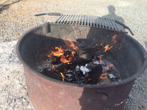 1997 Dodge 3500 - A fire burns in a metal pit, with a grill grate positioned overhead.