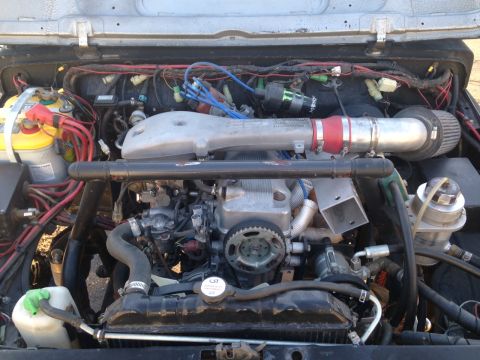 1987 Suzuki Samurai - Customized engine bay with aftermarket parts. Supermotors.net branding is present.