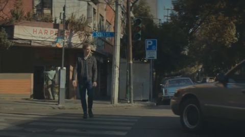 2000 Mercury Grand Marquis - A man crosses a street in front of a building with a sign that reads 'HARPERS'.