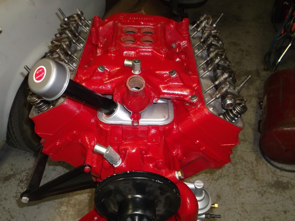 Red V8 engine with air cleaner, showing valve covers and intake manifold. Registry claims 1957 Ford Custom Sedan