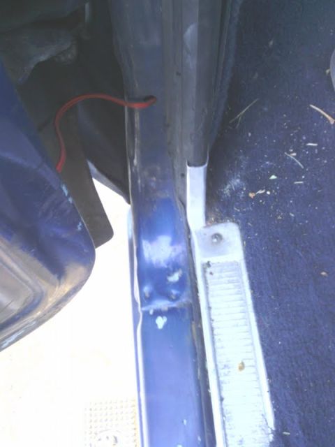 1978 Ford Bronco - Interior view of a vehicle's door jamb and floor, showing blue paint and carpet.