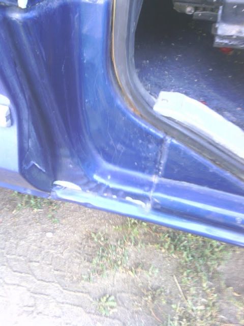 1978 Ford Bronco - Close-up of a blue vehicle's door jamb, showing wear and rust.