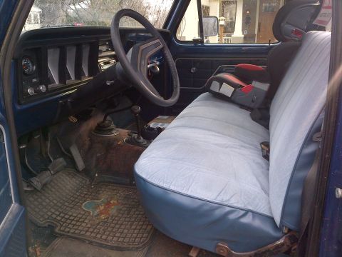 1978 Ford Bronco - Interior view of a 1978 Ford Bronco, complete with a child seat installed on the bench.