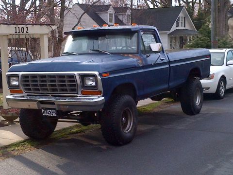 1978 Ford Bronco - This lifted blue pickup truck features a prominent front grille and appears to be from the late 1970s.