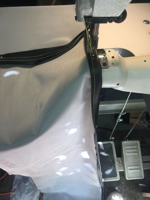 1993 Ford Bronco - A sewing machine is being used to stitch a black trim onto a light-colored cover, likely for a vehicle part.