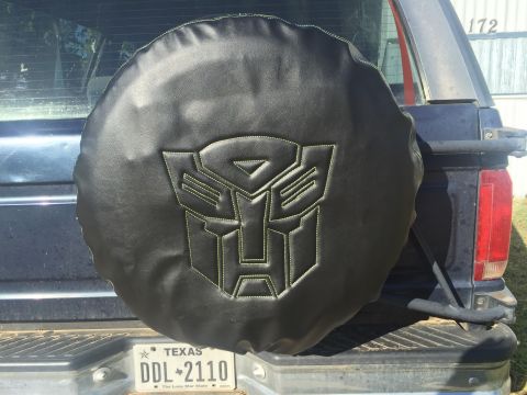 1993 Ford Bronco - 1993 Ford Bronco features a spare tire cover adorned with the iconic Transformers Autobot logo.