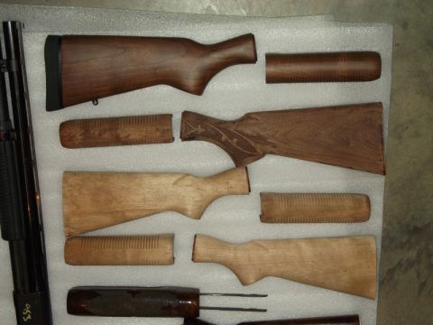1995 Mercury Grand Marquis - Various wooden gun stocks and forends are displayed on a white surface.