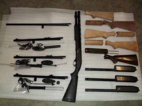 1995 Mercury Grand Marquis - Various shotgun components, including barrels, receivers, and wooden stocks, are arranged for display.