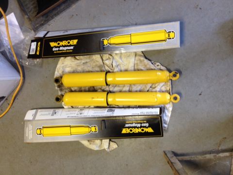 1973 Ford Bronco - Four yellow Monroe Gas-Magnum shock absorbers are laid out with their packaging.