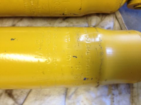 1973 Ford Bronco - Close-up of yellow shock absorbers with visible text indicating "MAGNUM" and "MADE IN U.S.A."