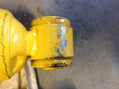 1973 Ford Bronco - Close-up of a yellow shock absorber showing significant paint wear.