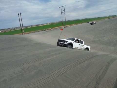 2005 Jeep Wrangler - White pickup truck navigates sandy terrain with a red flag marking its position.