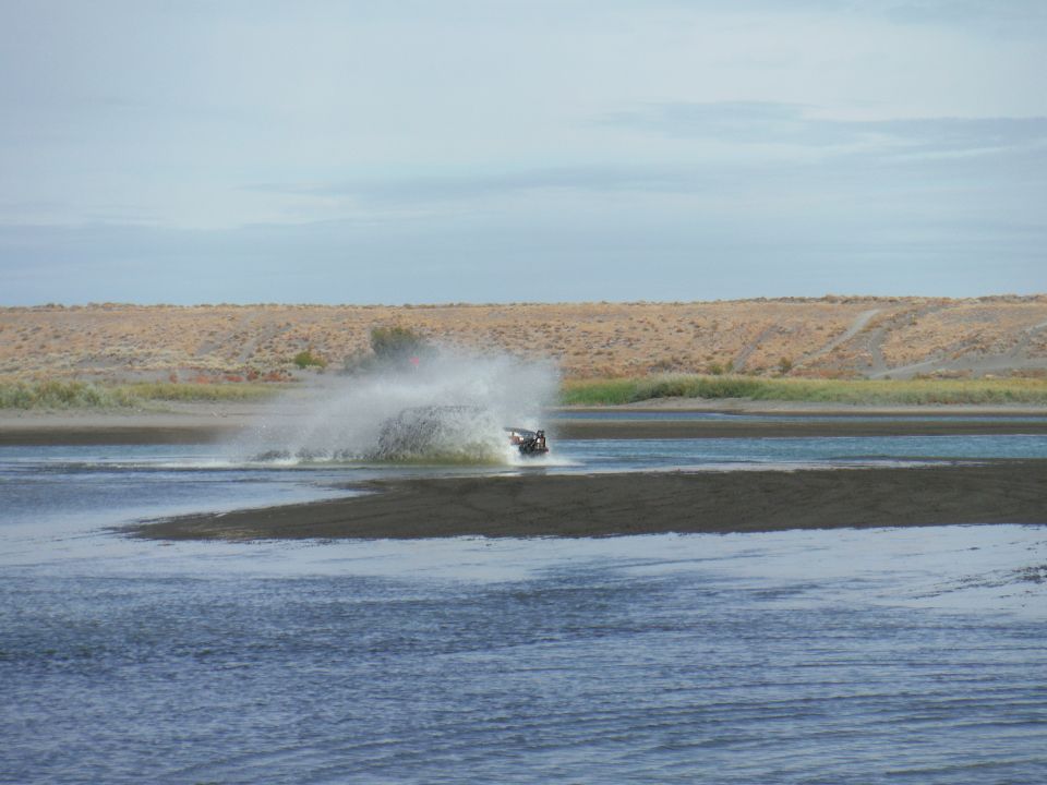 Black vehicle splashing water in a body of water