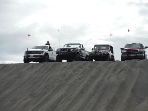 2005 Jeep Wrangler - A group of four-wheel-drive vehicles are lined up on a sandy incline, ready for off-road adventure.