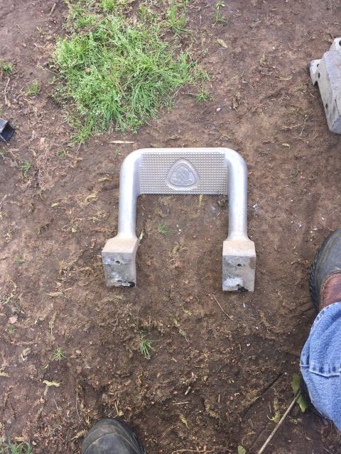 1993 Ford Bronco - A single vehicle step slider part is shown lying on the dirt ground.