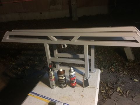 1993 Ford Bronco - Metal sliders are shown on a stand, accompanied by spray cans and a ruler, suggesting preparation for installation or maintenance.