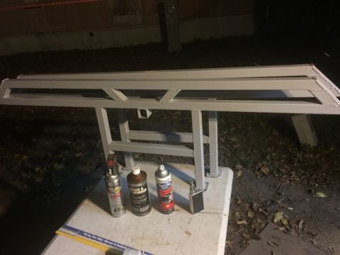 1993 Ford Bronco - Metal sliders on a stand with spray cans of primer, degreaser, and paint.