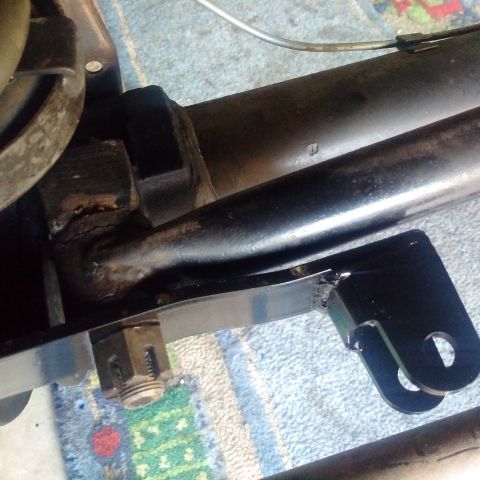 1978 Ford Bronco - A close-up view shows a black metal bracket attached to a black metal frame component, likely part of a vehicle's chassis or suspension sys…