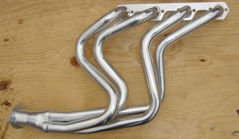 1986 Ford Bronco - Chrome exhaust headers are shown laid out on a wooden surface.