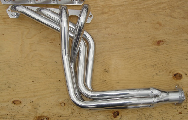 chrome exhaust headers on a wooden surface