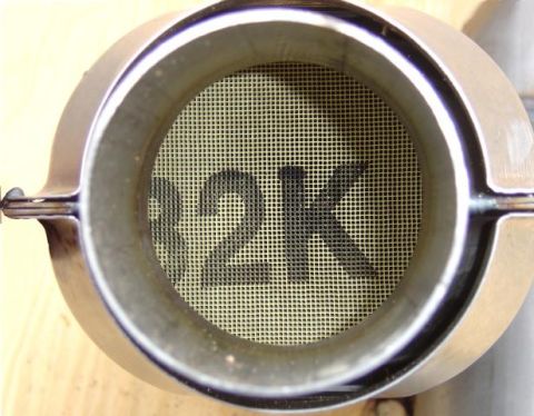 1986 Ford Bronco - Close-up view of the interior of a catalytic converter, showing the honeycomb structure with "12K" imprinted on it.