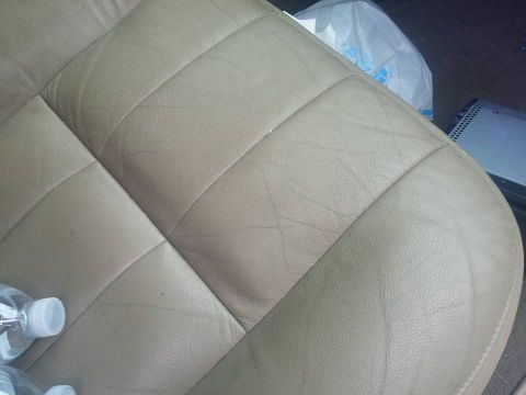 2000 Mercury Grand Marquis - Interior view of a tan leather car seat with diamond stitching and visible wear.