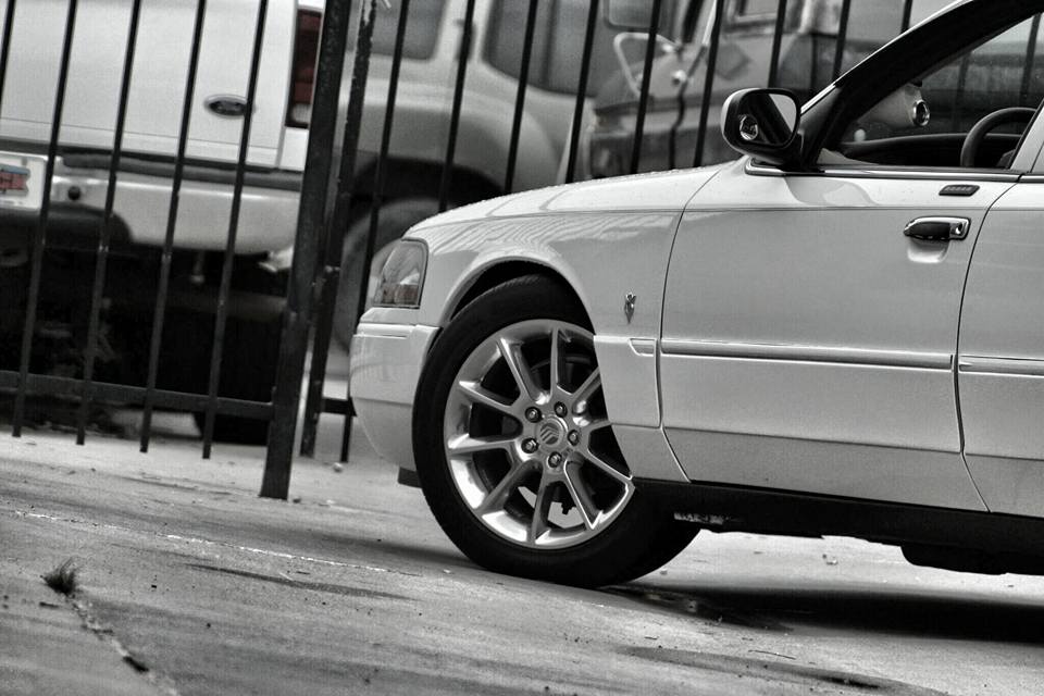 Close-up of a white sedan front wheel and fender