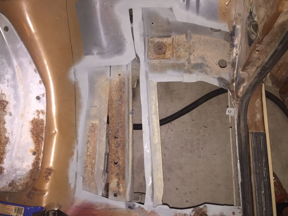 Close up of a vehicle engine bay with rust and primer