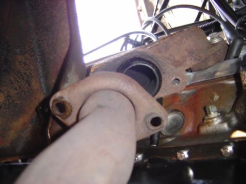 1986 Ford Bronco - Close-up view of an exhaust manifold and pipe connection, with visible rust and hardware.