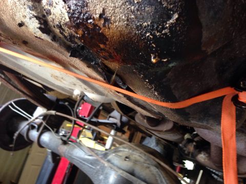 1979 Ford Bronco - An underside view of a vehicle shows a heavily soiled and greasy metal component, possibly the undercarriage or a differential housing, wit…