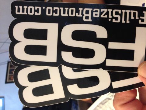 1979 Ford Bronco - A hand holds two black and white stickers with the text "FSB" and "fullsizebronco.com" printed on them.