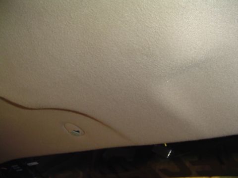 1999 Ford Taurus - The interior headliner of a vehicle shows signs of sagging and has a circular light fixture.