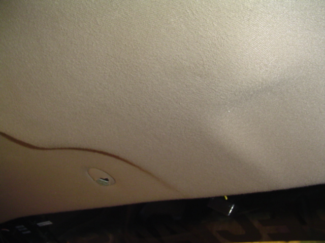 Car's headliner with a sagging section and a light fixture