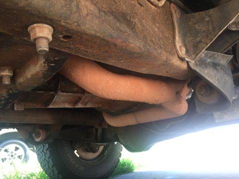 1993 Ford Bronco - The underside of a 1993 Ford Bronco shows the exhaust system, frame rails, and suspension components. The frame and exhaust pipes are cover…