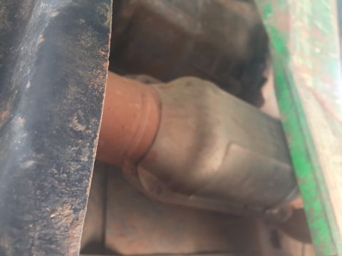 1993 Ford Bronco - This image shows the underside of a vehicle, focusing on the exhaust system. A catalytic converter is visible, connected to a pipe.